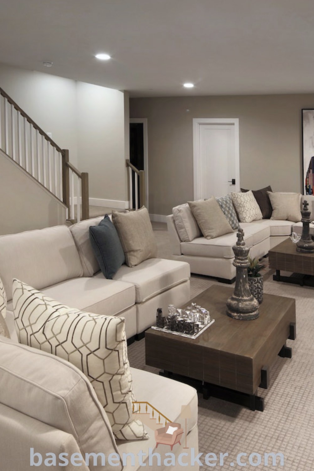 A stylish living room in a basement apartment with comfortable furniture, a flat-screen TV mounted on the wall, and an inviting decor aesthetic. This basement living room showcases contemporary decor and innovative ideas for designing functional spaces, perfect for entertaining and family enjoyment. Explore more at basementhacker.com.