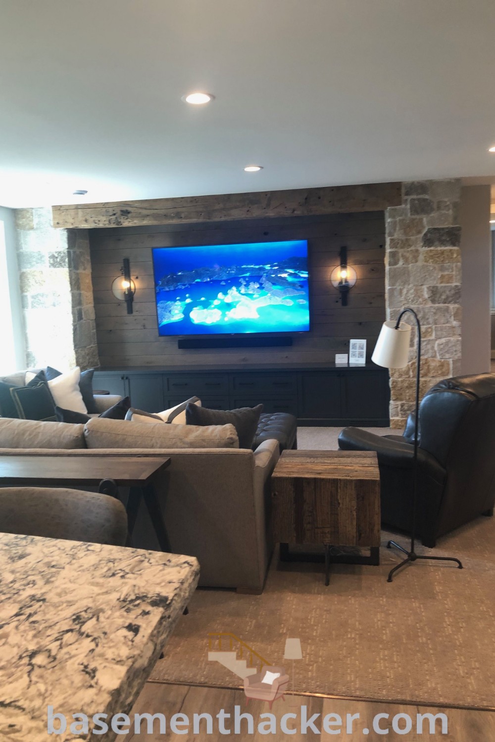 A living room filled with furniture, including a cozy couch and a flat screen TV on the wall, showcasing innovative basement TV wall ideas perfect for family enjoyment. Discover more stylish and functional home design options at basementhacker.com.