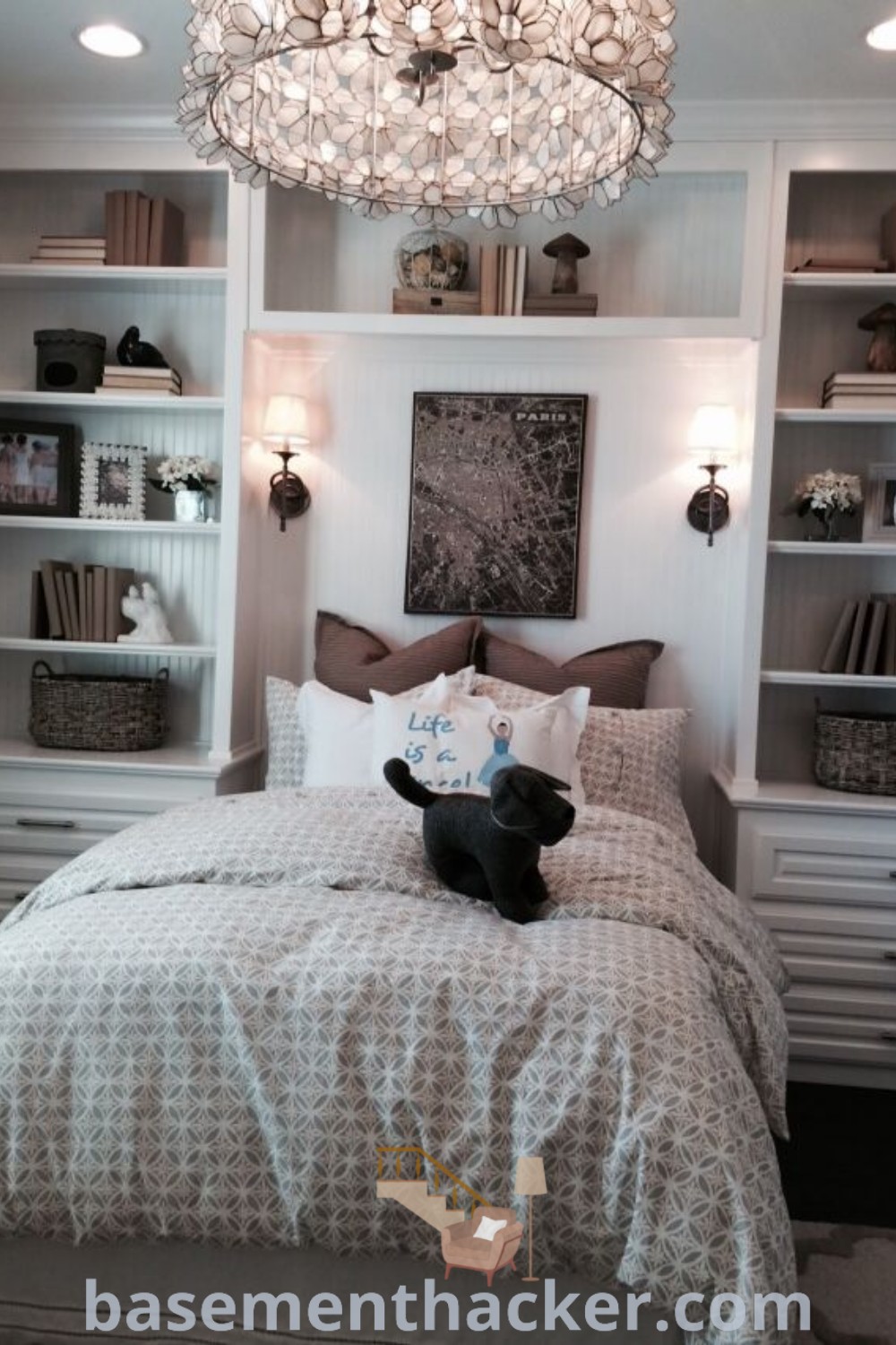 A beautifully arranged bedroom showcasing a neatly made bed, a chandelier hanging from the ceiling, and built-in shelves that offer functional storage solutions. This space integrates innovative ideas for designing a cozy and organized home, providing inspiration for stylish bedroom decor. Explore more design concepts at basementhacker.com.