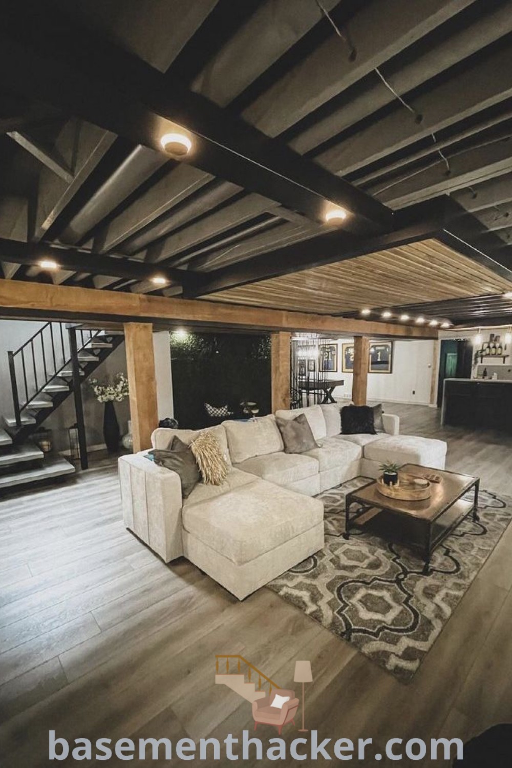 A cozy living room featuring furniture and a fireplace on a wooden floor, representing innovative ideas for designing an unfinished basement into a stylish space for ultimate entertaining. Explore more awesome basement ideas at basementhacker.com.