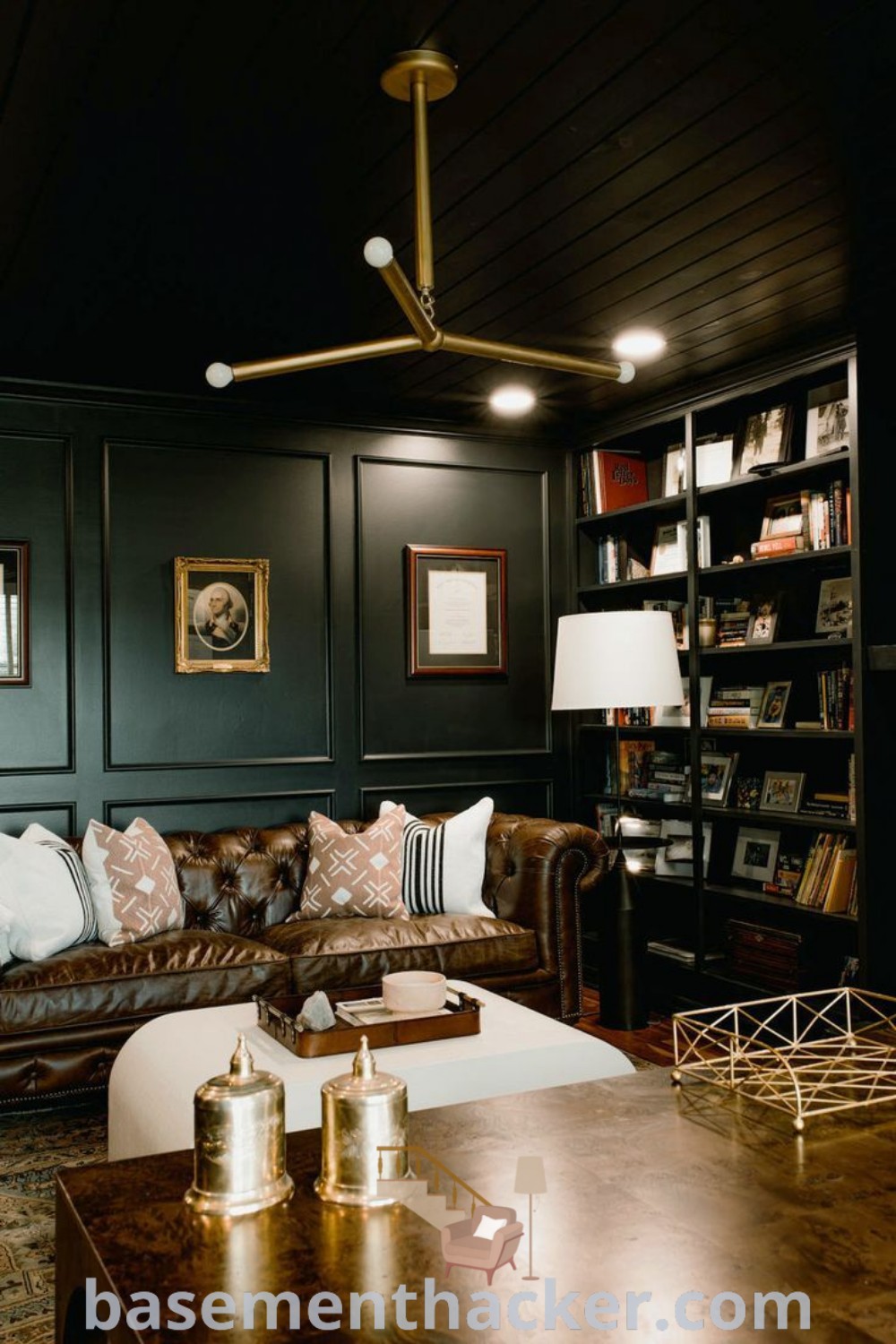 A living room designed as a stylish man cave office, featuring comfortable furniture, bookshelves, and decor elements inspired by a whiskey lounge aesthetic. This space combines functionality and elegance, offering innovative ideas for designing the ultimate entertaining area. Explore more at basementhacker.com.