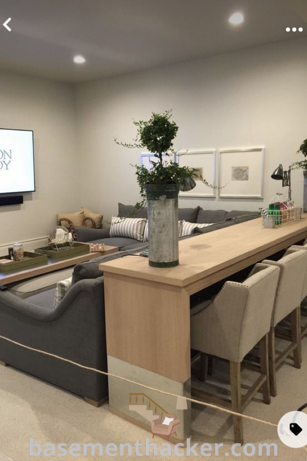 A living room filled with furniture and a flat-screen TV mounted on the wall, showcasing stylish basement living room ideas for ultimate entertaining. This beautifully designed space emphasizes innovative basement makeovers and is featured on basementhacker.com.