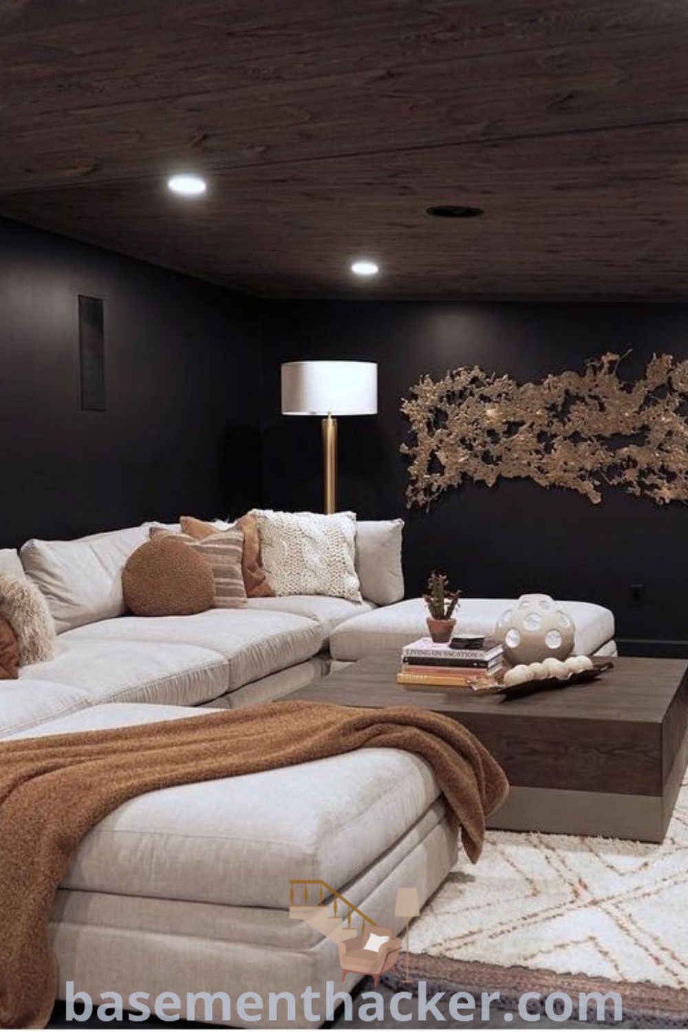 A cozy living room with a flat-screen TV mounted on the wall, showcasing various design ideas for a stylish and functional basement media room. This innovative space incorporates gray room ideas and basement movie room concepts for ultimate entertaining. Explore more design inspirations at basementhacker.com.