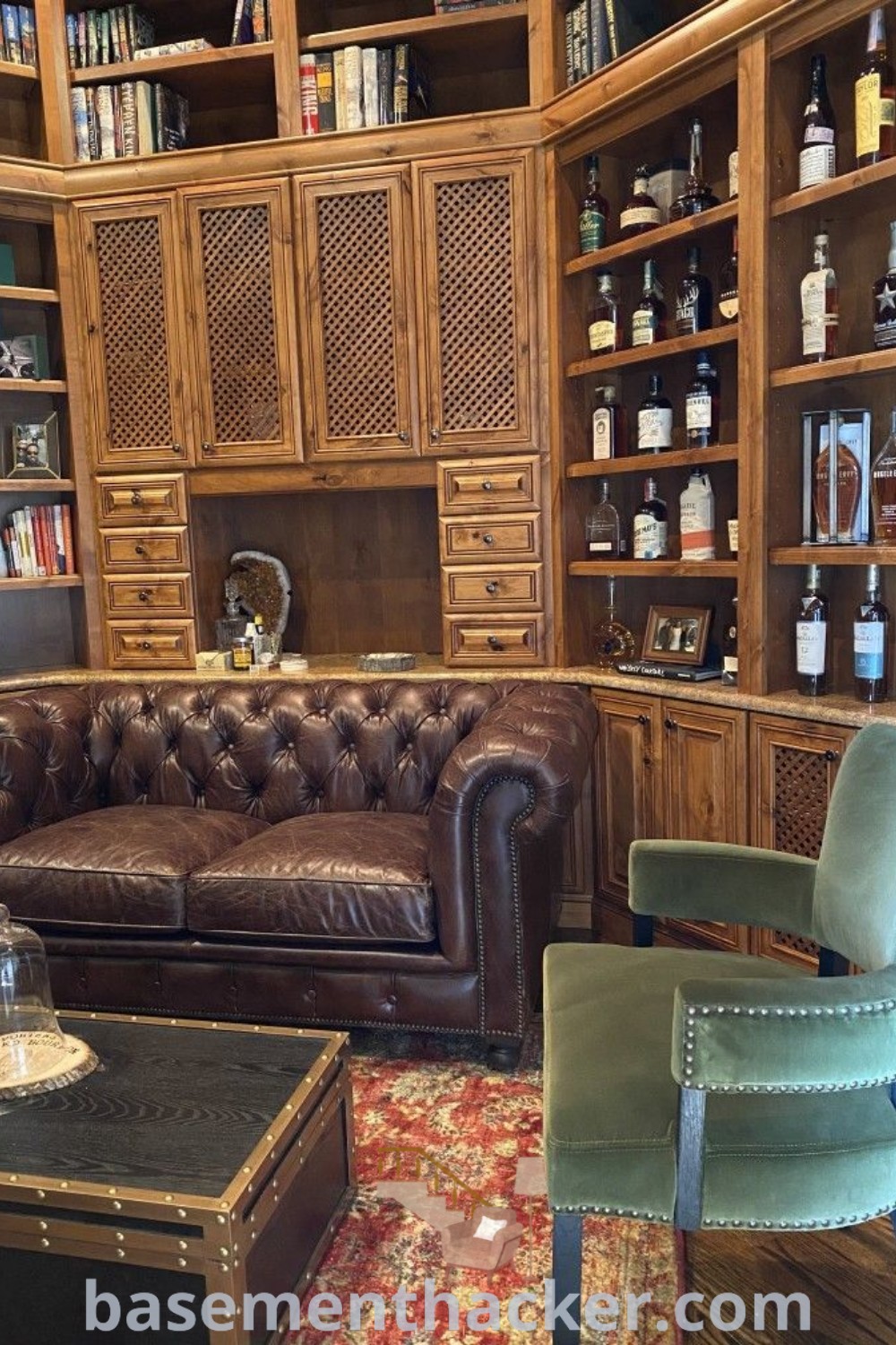 A stylish living room showcasing a whiskey corner with a caramel leather sofa, extensive bookshelves, and masculine decor elements. This image exemplifies innovative ideas for designing a whiskey library and offers insights for creating a cozy and functional home. For more inspiration, visit basementhacker.com.