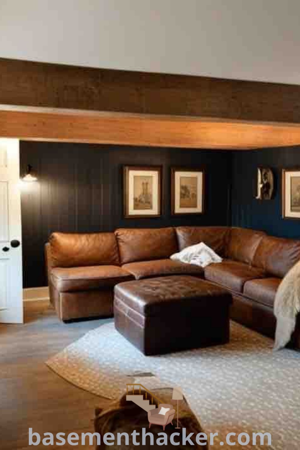 A cozy living room in a basement with leather furniture and decorative pictures on the wall, showcasing innovative design ideas for a stylish and functional family space. Perfect for remodeling, this room offers inspiration for basement living rooms and cozy basement ideas. Find more innovative basement makeover ideas at basementhacker.com.