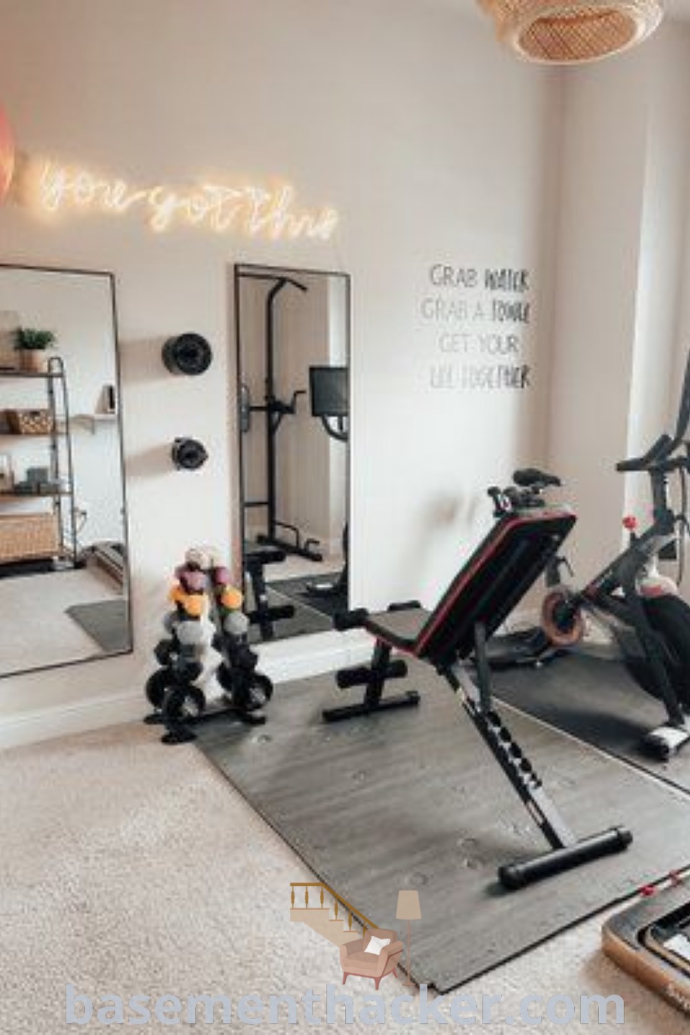 A stylish home gym featuring exercise equipment and mirrors, offering innovative ideas for personal training studio design and workout room ideas. This space is perfect for mini gym at home concepts and enhancing home exercise rooms. Find more inspiring gym decor ideas at basementhacker.com.