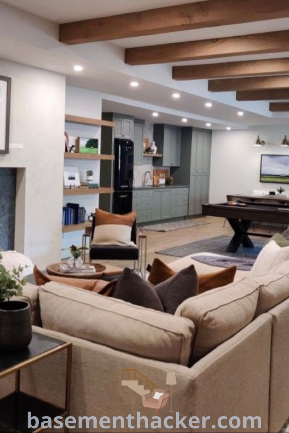 A cozy basement lounge featuring furniture, a fireplace, and a pool table, creating an inviting atmosphere for ultimate entertaining. This basement decor showcases innovative ideas for a stylish bonus space, perfect for family gatherings. For more inspiring design ideas, visit basementhacker.com.