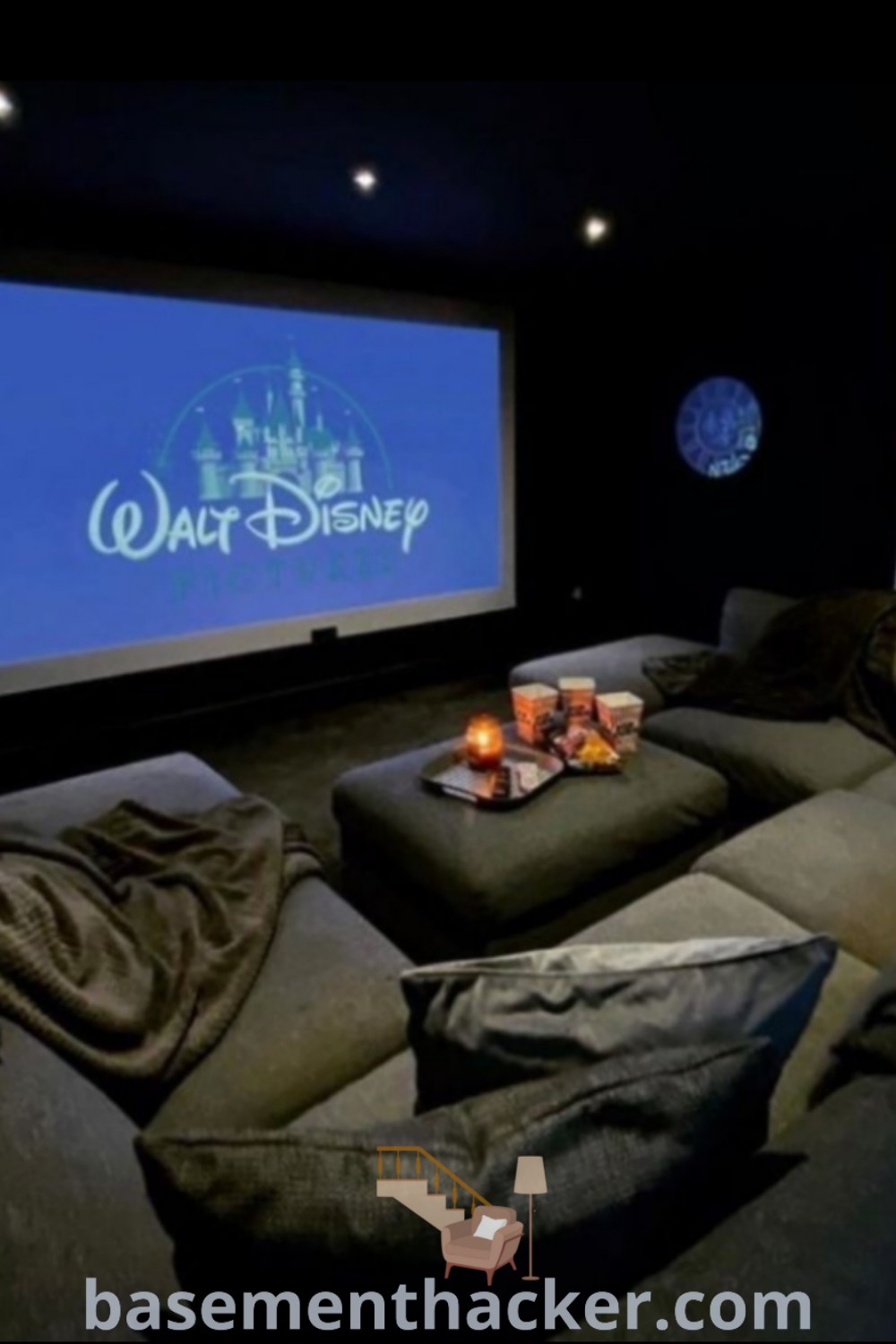 A stylish home theater room with two comfortable couches and a projector screen, ideal for movie nights and family fun. This innovative design offers ideas for a stylish and functional bonus space, enhancing your entertainment options. Discover more inspirations for your cinema room at basementhacker.com.