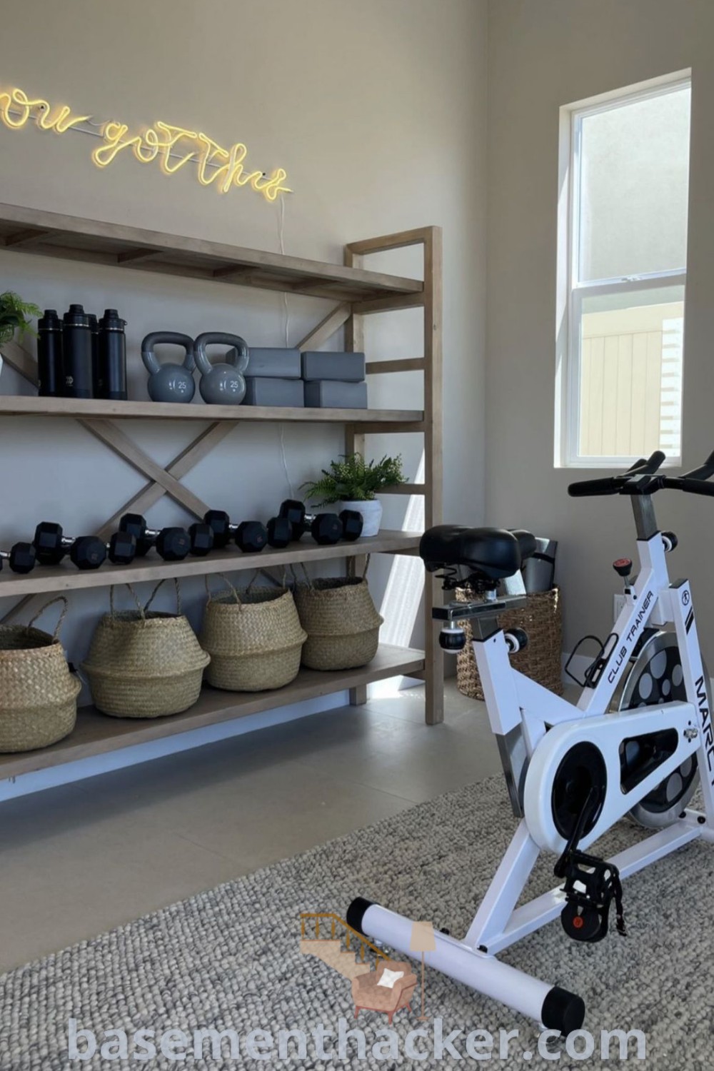 A stylish home gym with a bike at the center, surrounded by baskets on the floor and shelves behind it, showcasing innovative ideas for a functional home gym setup. Perfect for small spaces or a gym and movie room combo, this design offers clever solutions for creating a cozy atmosphere for ultimate entertaining. For more ideas, visit basementhacker.com.