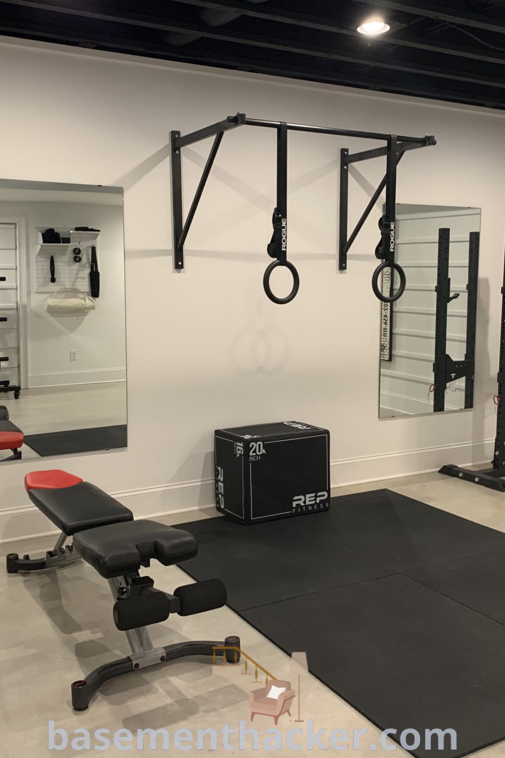 A clean and inviting basement gym ready for exercise, featuring innovative basement makeover ideas and stylish decor. This space showcases functionality and aesthetic appeal for an ultimate workout experience, offering inspiration from basementhacker.com.