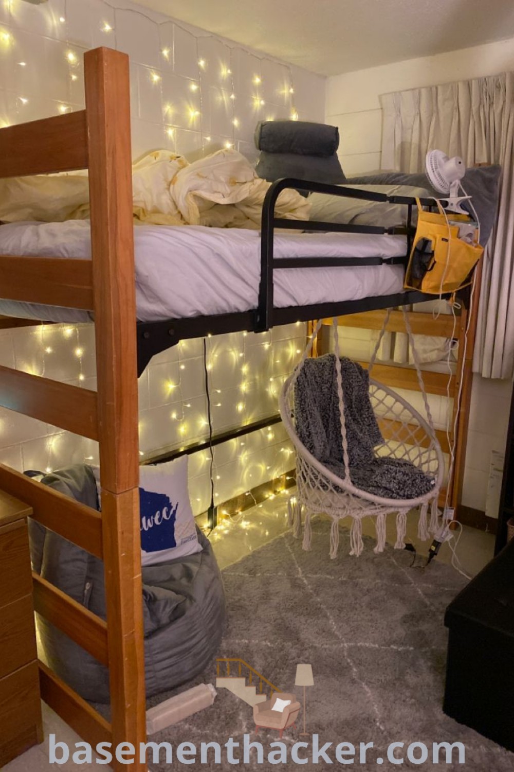 A cozy dorm room with a bunk bed decorated with fairy lights, showcasing innovative top bunk bed decorating ideas for a stylish and functional space. This aesthetic design incorporates the latest trends in bunk bedroom decor, providing lots of room ideas for a cozy and organized home. Check out more inspiration at basementhacker.com.