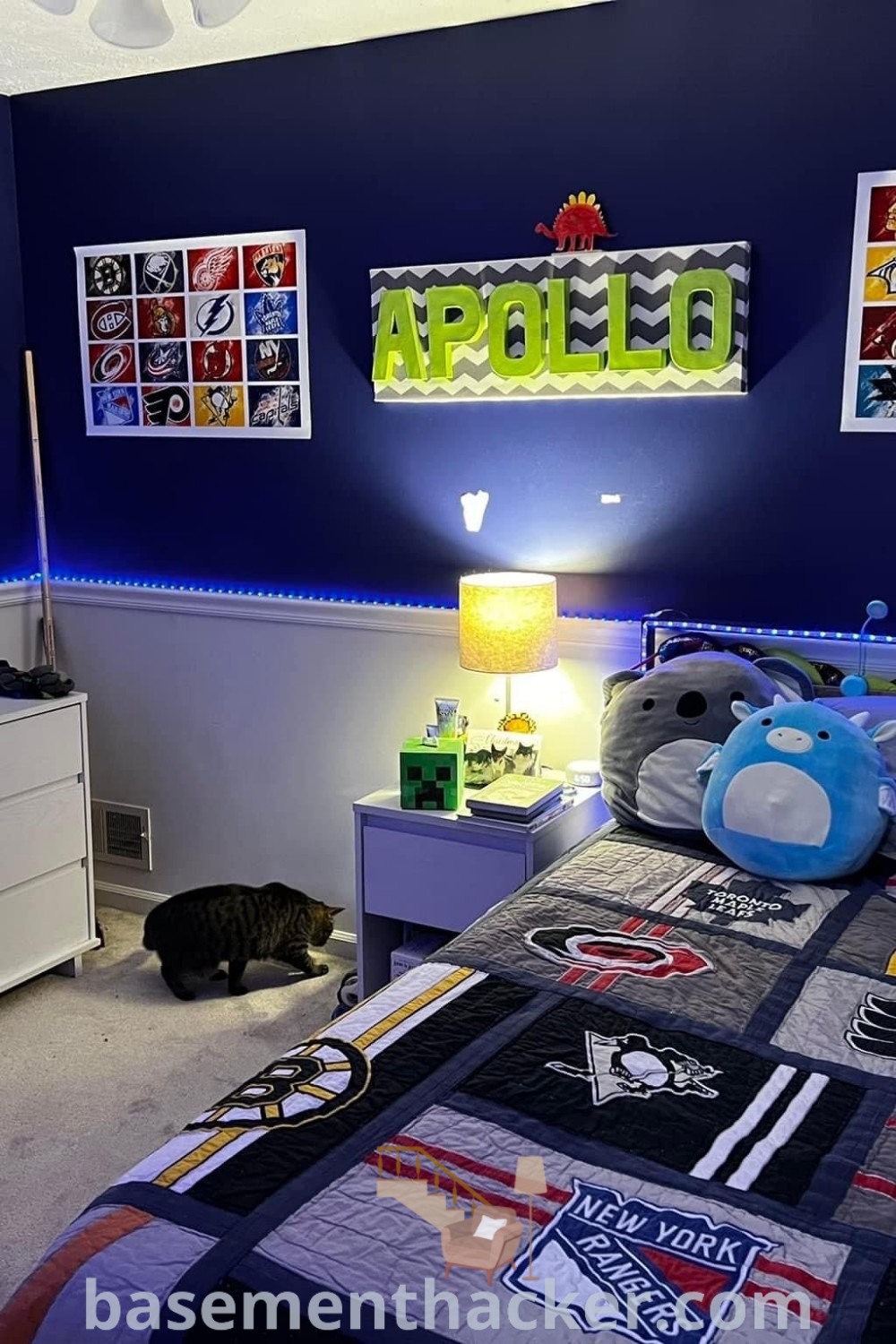 A cozy boys bedroom at night showcasing a small double bed with vibrant bedding, pictures on the wall, and a stylish dark blue bed ideal for boys aged 6 years. This design exemplifies innovative ideas for a stylish and functional home. Discover more at basementhacker.com.