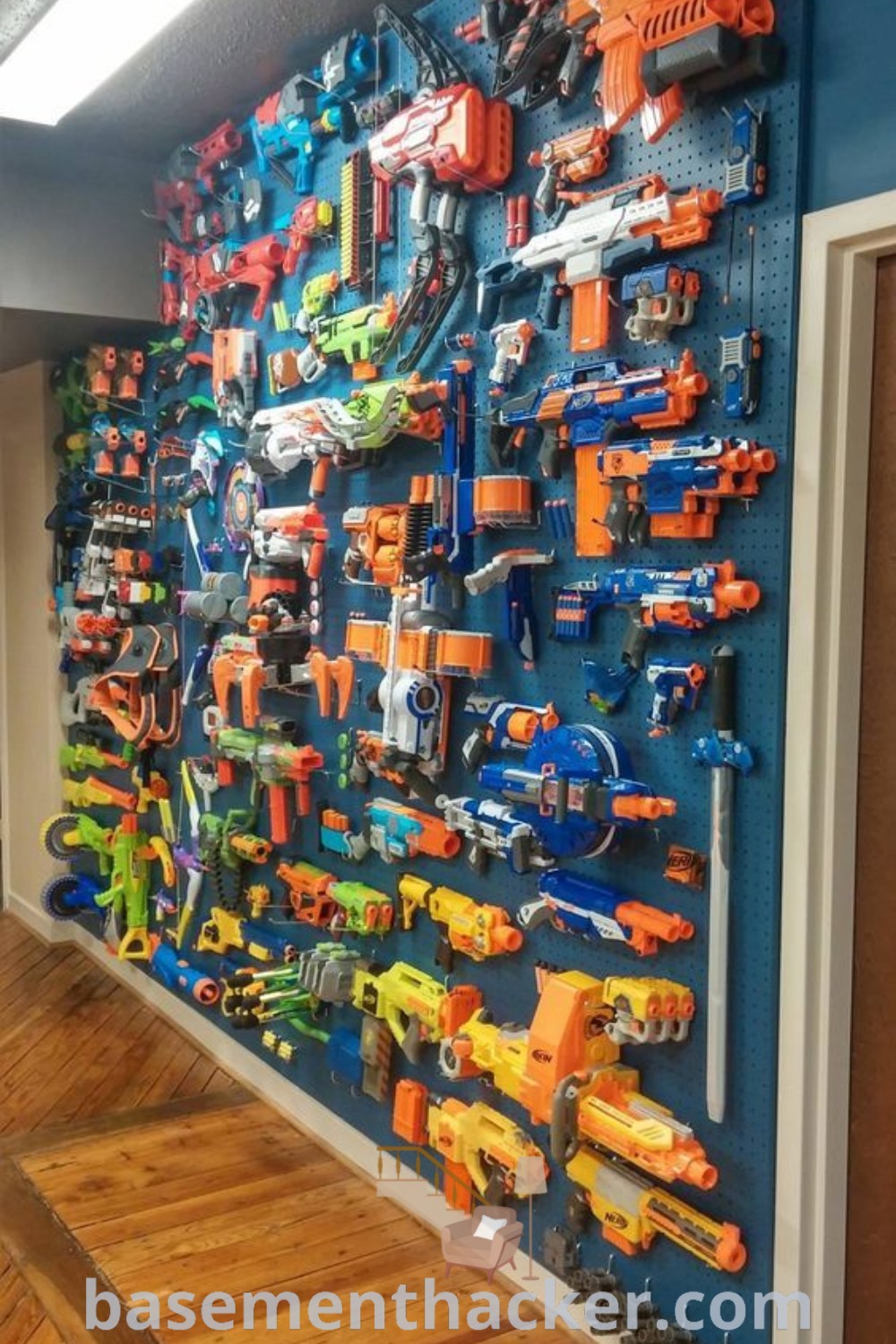 A stylish gamer room designed for boys, featuring a vibrant Nerf wall and innovative nerf storage. This fun space showcases video game rooms and toy room ideas that are perfect for ultimate entertaining. Discover creative design ideas for a cozy and organized home at basementhacker.com.
