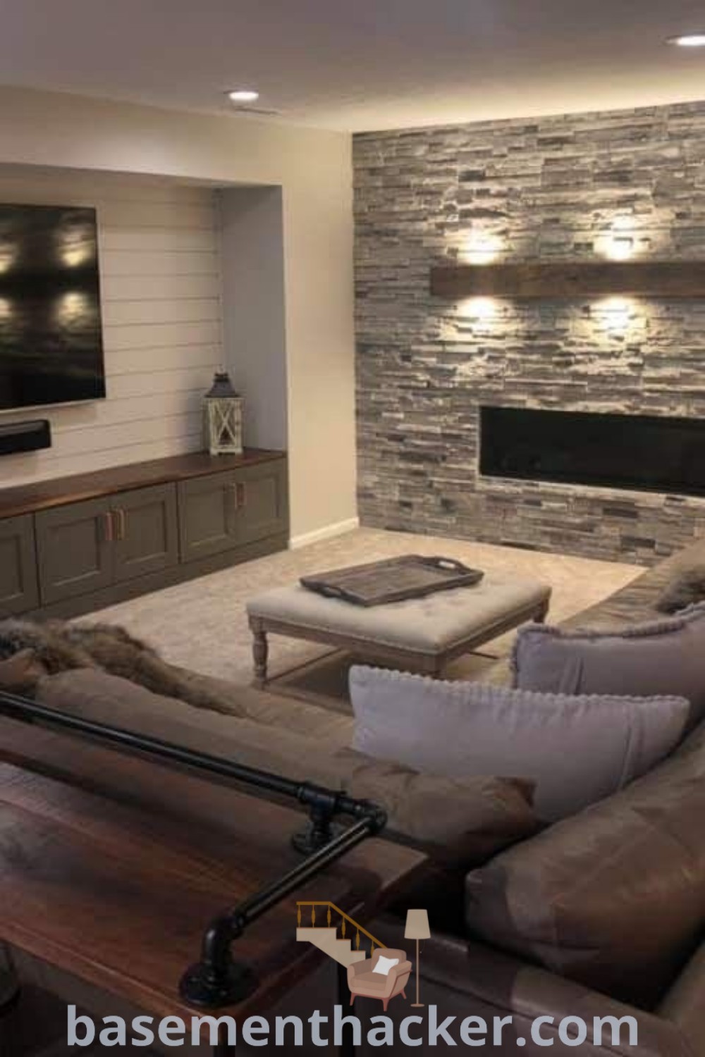 A cozy basement living room showcasing couches, a flat-screen TV mounted over a fireplace, and inviting decor, perfect for family movie nights. This space represents stylish bonus room design ideas for families, combining warmth and functionality in your home. For more stunning basement designs, visit basementhacker.com.