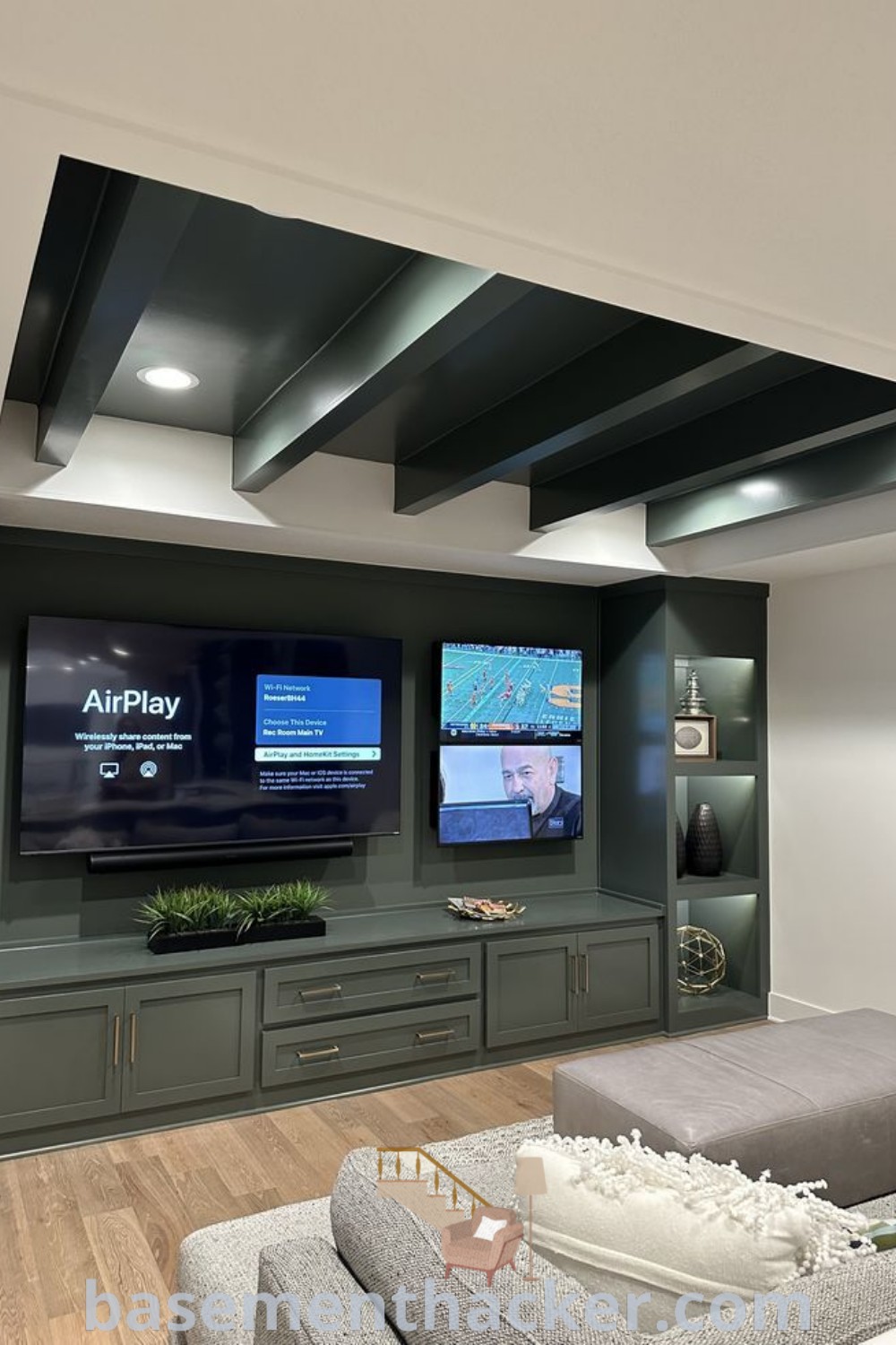 A living room filled with furniture showcasing two flat-screen TVs mounted on the wall, representing stylish multi-TV basement ideas for ultimate entertaining. Explore unique designs like a green media wall and bar and TV room setups on basementhacker.com for innovative setup tips.