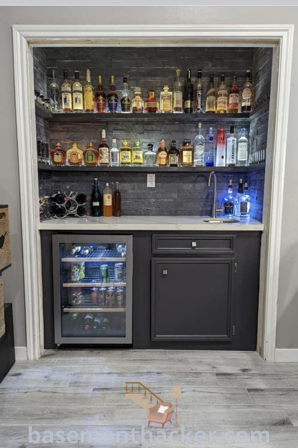 A stylish closet mini bar featuring liquor bottles neatly displayed on shelves and a mini fridge, showcasing innovative ideas for designing a functional and elegant space for ultimate entertaining. Discover more at basementhacker.com.
