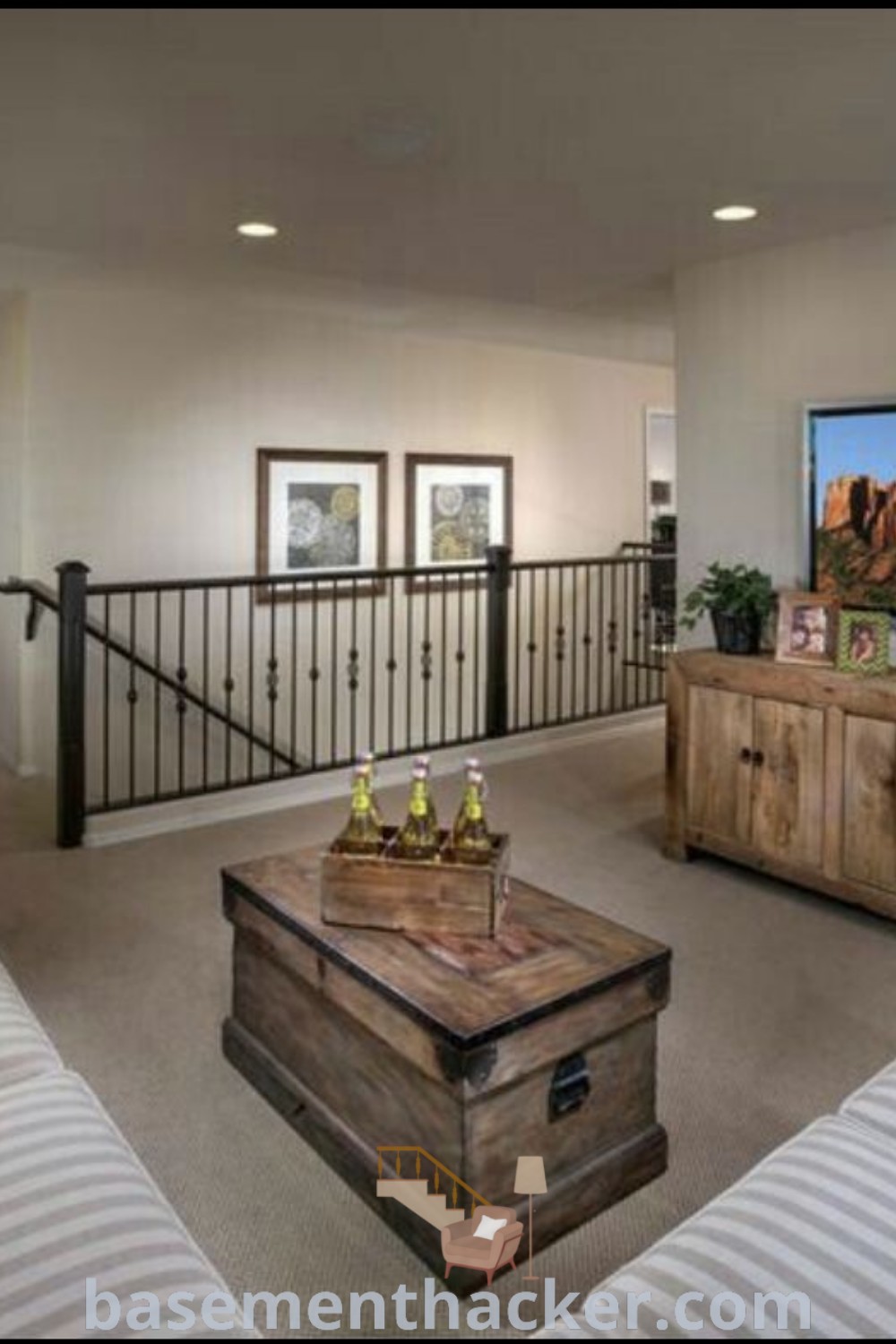 A stylish loft living room featuring furniture and a flat screen TV mounted on the wall, showcasing loft decorating ideas for an upstairs loft or bonus room. This design offers innovative ideas for a cozy and organized home, perfect for ultimate entertaining and enhancing your living space. Find more tips at basementhacker.com.