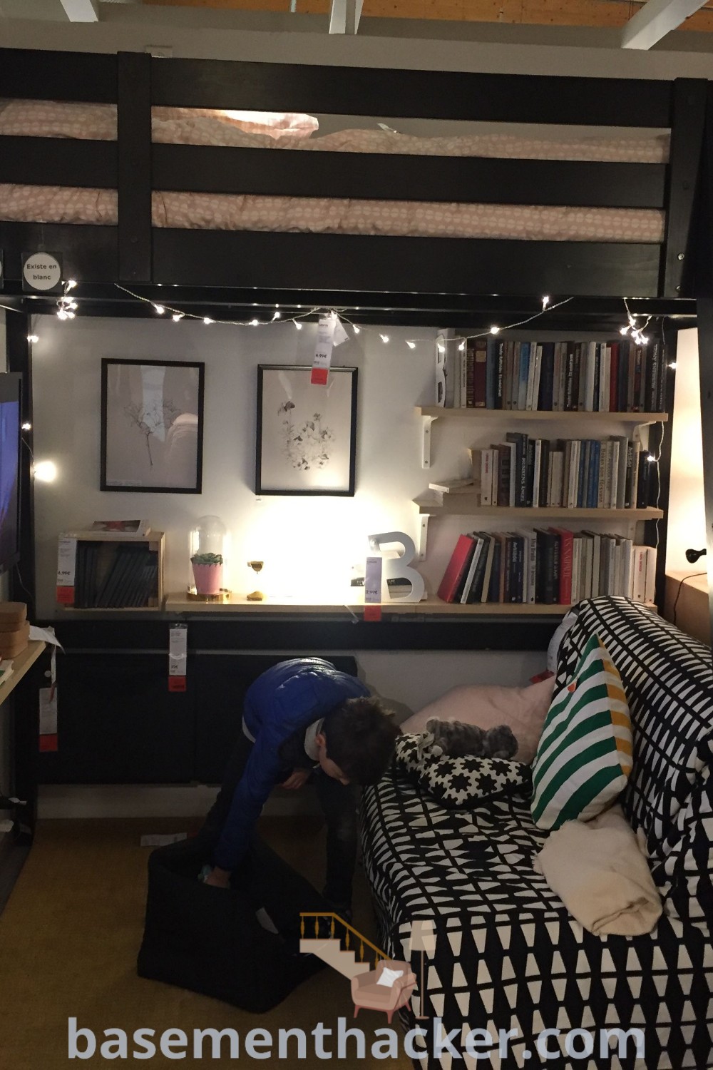 A loft bed in a cozy room, adorned with bookshelves and decorative items, showcasing innovative ideas for designing small spaces and stylish bedroom aesthetics. Explore loft bed plans and inspiration for a functional and organized living area at basementhacker.com.