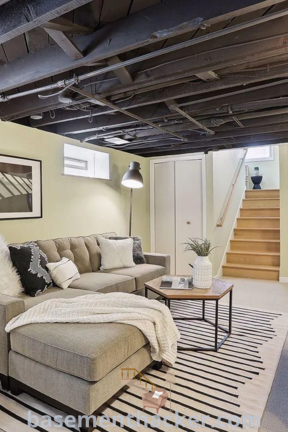 A cozy living room filled with furniture and a decorative staircase, adjacent to a fire hydrant, showcasing innovative basement makeover ideas for a stylish and functional space. Discover the best basement remodeling ideas for creating inviting environments at basementhacker.com.