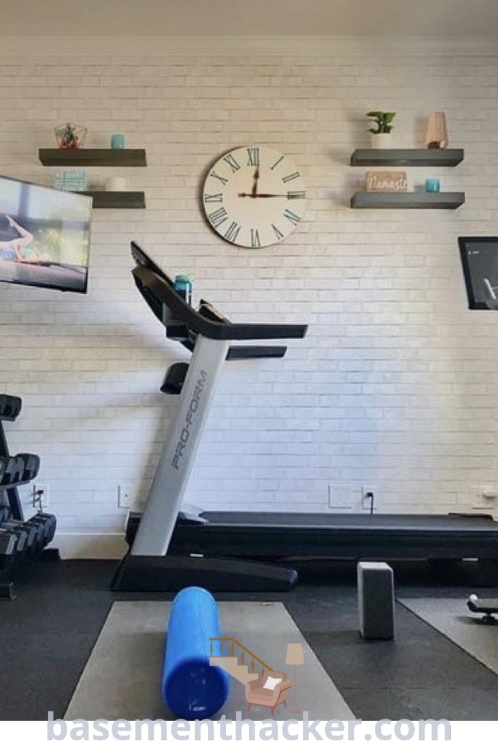 A small home gym featuring a treadmill, exercise bikes, and a flat-screen TV, designed for functionality and aesthetic appeal. This smart setup showcases innovative ideas for a cozy and organized home gym, perfect for small spaces. Discover more inspiring designs and tips at basementhacker.com.