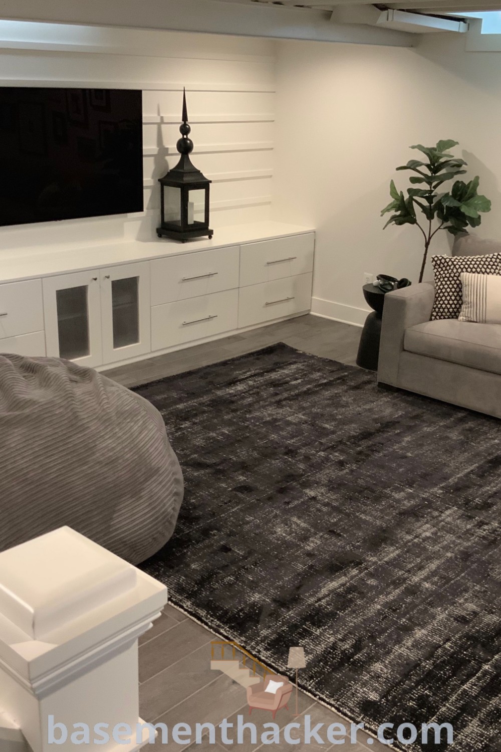 A clean and inviting living room designed as an entertainment center, showcasing stylish basement decoration ideas, game room inspirations, and gray basement aesthetics. This space is perfect for the ultimate entertaining experience, offering innovative basement makeover concepts found at basementhacker.com.