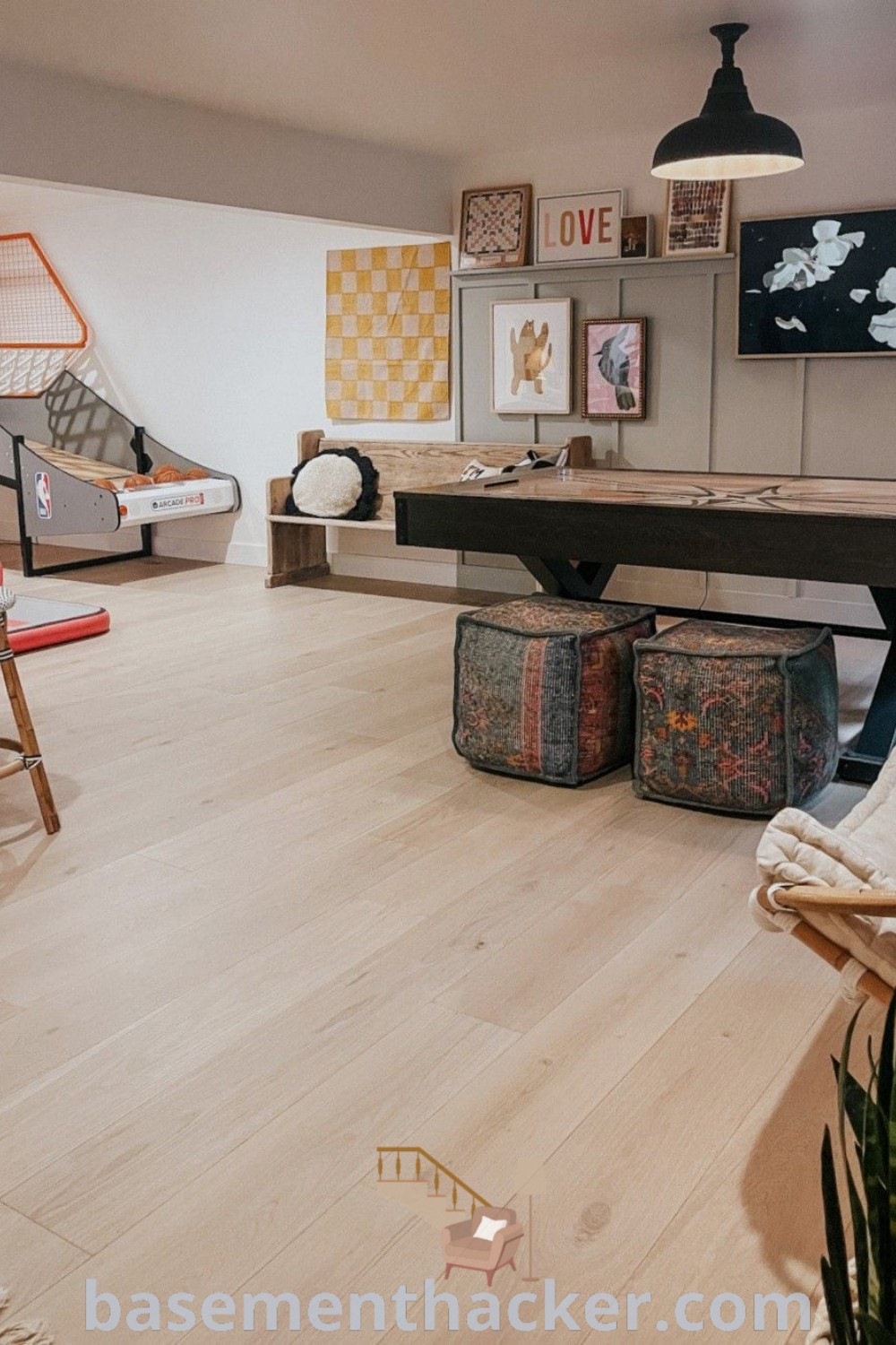 A living room featuring a stylish combination of furniture and decor, designed as a game room built-in for ultimate entertaining. This inviting space illustrates innovative basement makeover ideas suitable for a sporty basement and finished basement game room. Find more design inspirations at basementhacker.com.