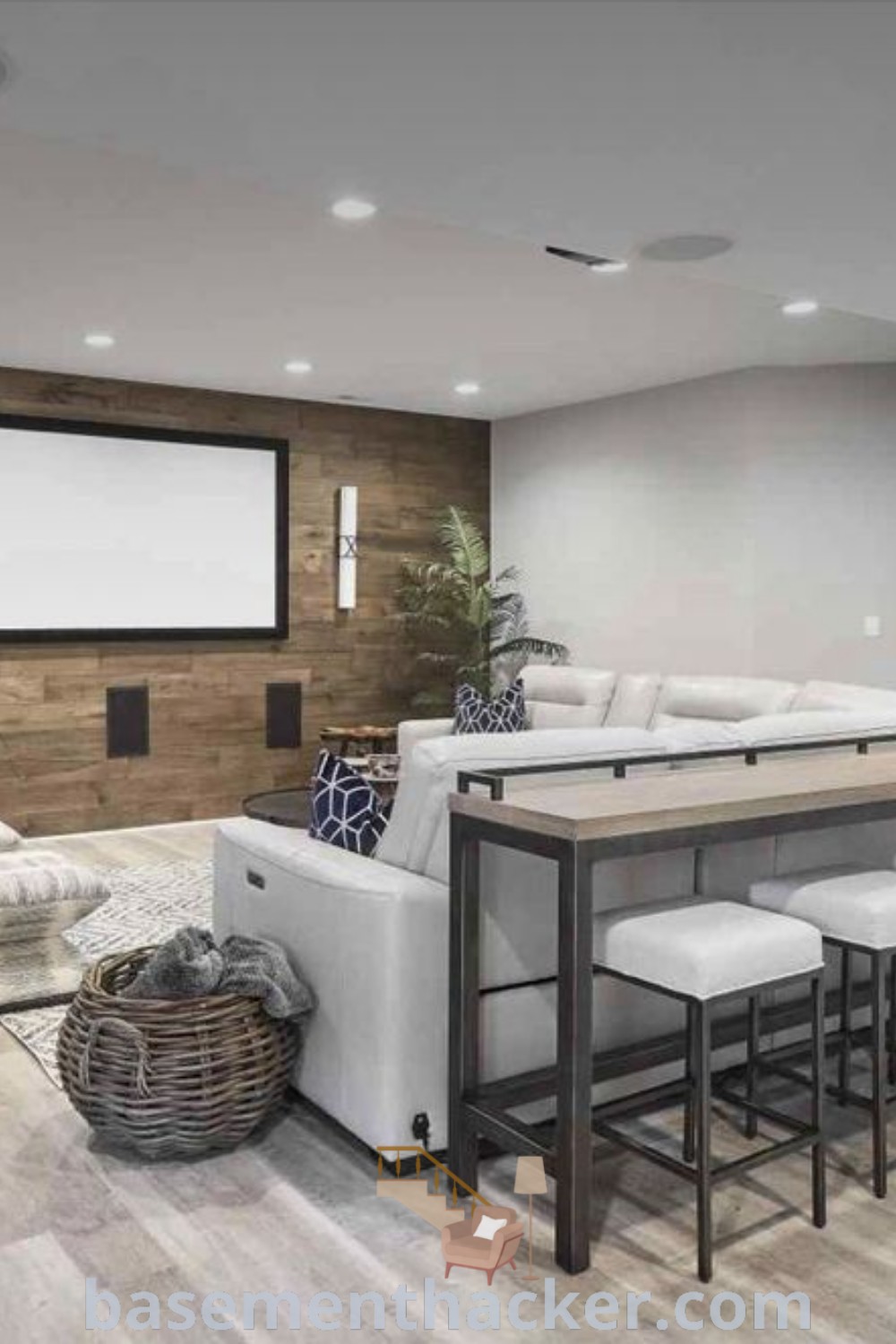 A stylish basement living room filled with modern furniture and a flat-screen TV, ideal for cozy family gatherings and entertaining. Discover awesome basement makeover ideas for a stylish and functional home design at basementhacker.com.