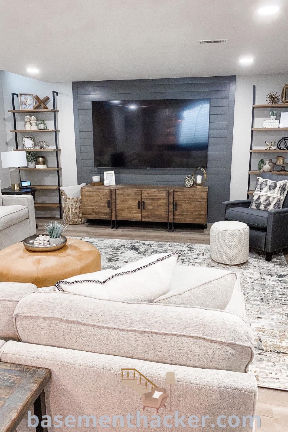 A cozy basement living room featuring stylish furniture, a flat screen TV mounted on the wall, perfect for families seeking innovative ideas for a stylish and functional home design. This space embodies the best basement remodeling ideas for your home, as showcased on basementhacker.com.