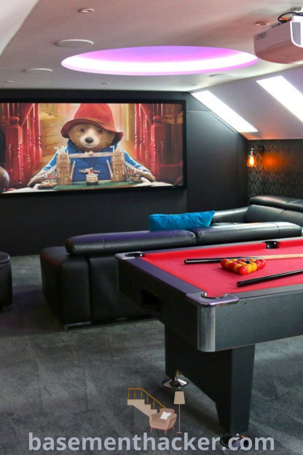A luxury gaming room featuring a pool table, comfortable couches, and a projector screen in the corner, designed for ultimate entertaining. This space offers innovative ideas for small game rooms and home theater room designs, perfect for family gatherings. Discover more stylish bonus room design ideas at basementhacker.com.