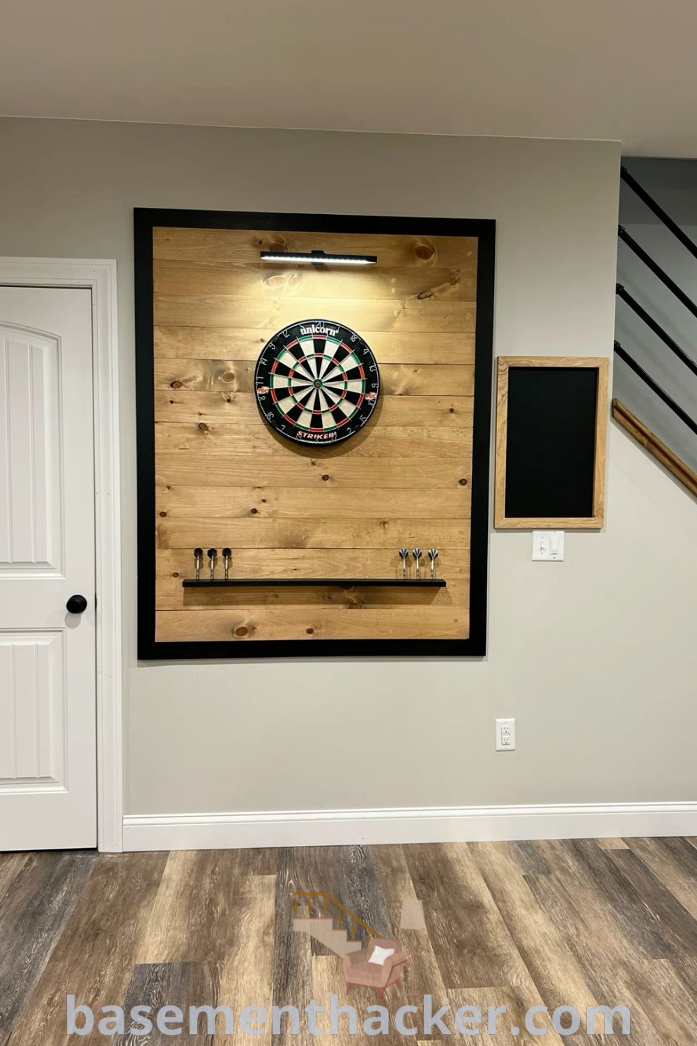 A dart board mounted on a barnwood wall in a stylish basement, showcasing innovative ideas for designing a cozy and organized home space. This setup is perfect for man cave dart board inspiration and DIY gym decor ideas for ultimate entertaining, featured on basementhacker.com.
