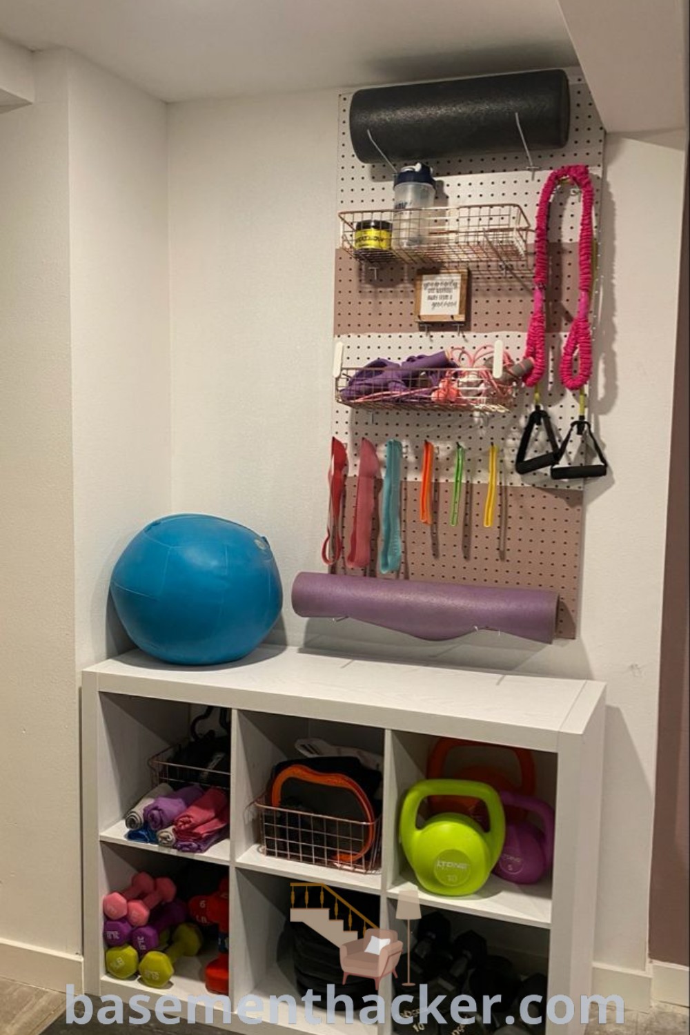 A white shelf filled with diverse sports equipment and accessories, showcasing innovative ideas for designing a gym office combo and maximizing garage space for home workout equipment storage. For more organization inspiration, visit basementhacker.com.
