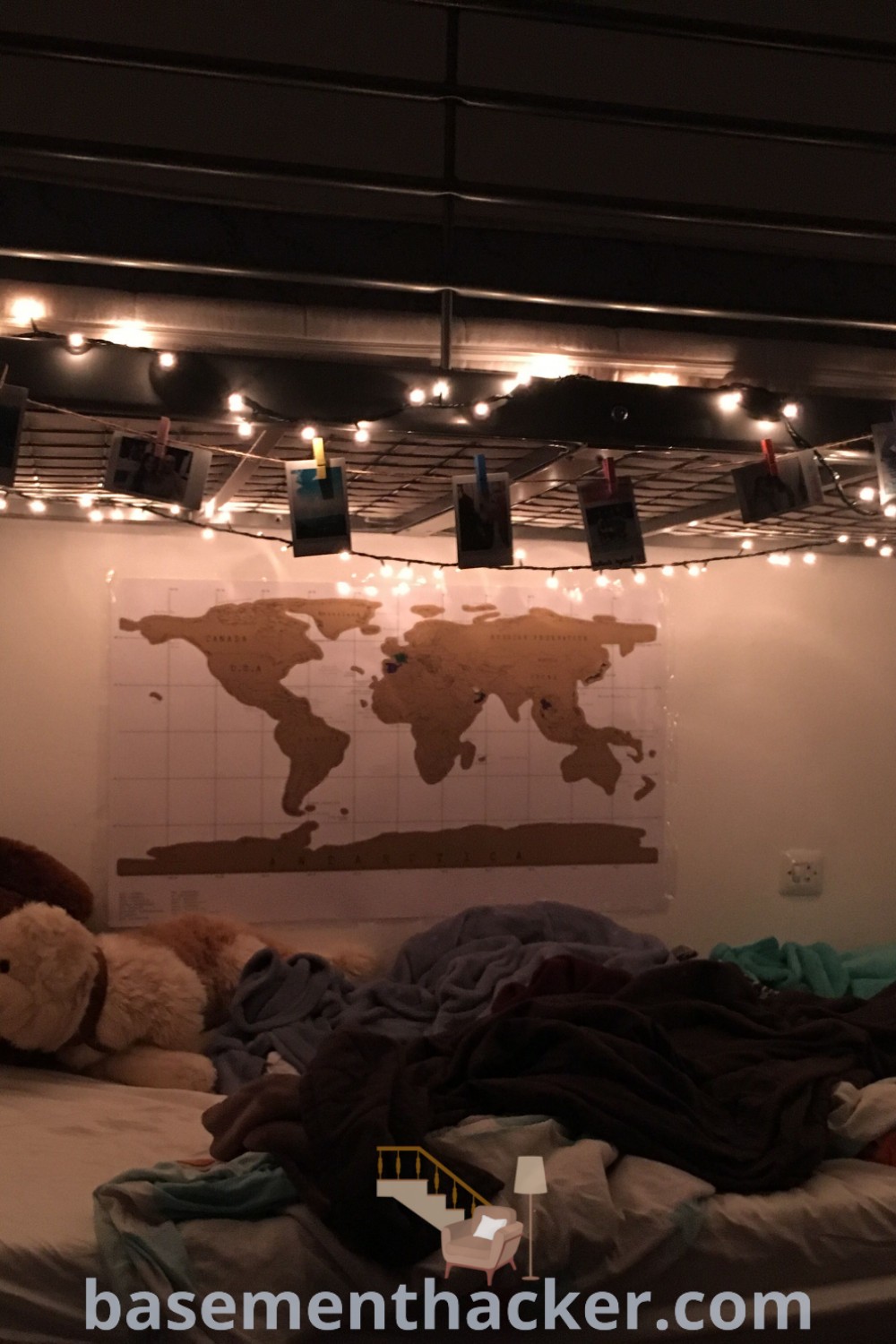 A cozy dorm room with a world map above the bed, showcasing bottom bunk fairy lights that create a whimsical atmosphere. This aesthetic design inspires unique bunk bed decorating ideas with lights, making it a stylish and functional space for ultimate entertaining. Explore more innovative ideas for designing bedrooms at basementhacker.com.