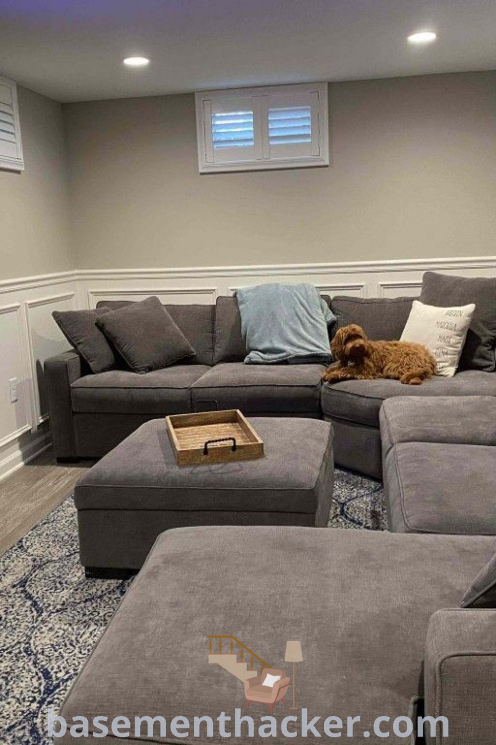 A cozy living room with grey couches and a flat screen TV mounted on the wall, showcasing small family room ideas and innovative basement makeover inspiration. This space is perfect for remodeling, offering stylish bonus room design ideas for families to enjoy together. Discover even more tips at basementhacker.com.