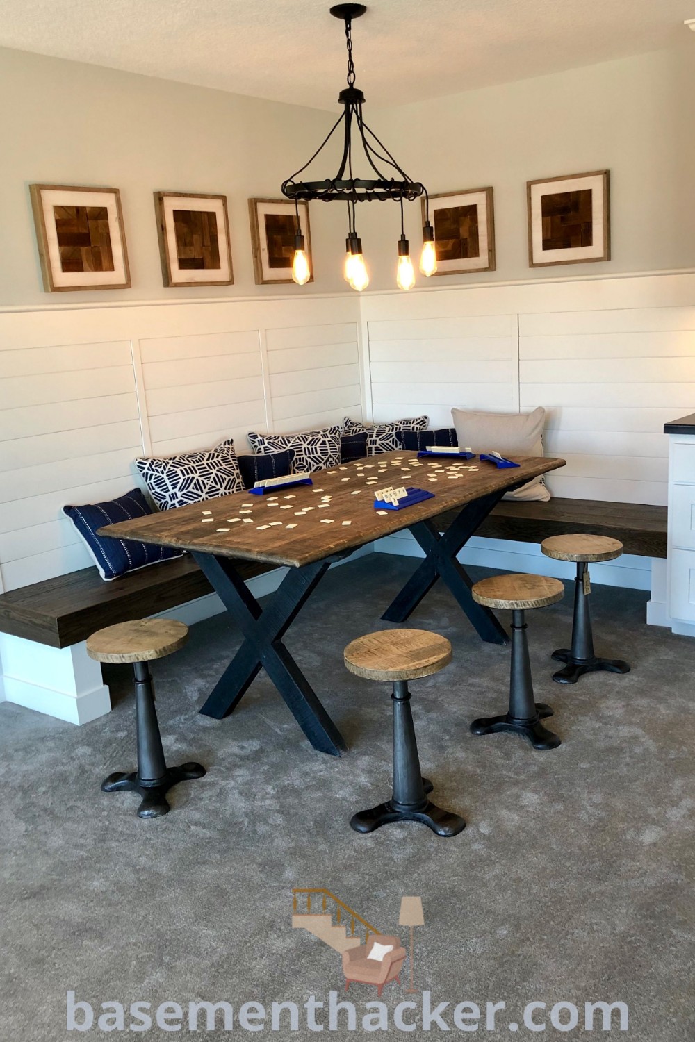 A dining room table with four stools in front, designed for a cozy game room setting that encourages family interaction. This space integrates innovative basement makeover ideas and stylish game room designs for ultimate entertaining. Explore more decorating tips at basementhacker.com.