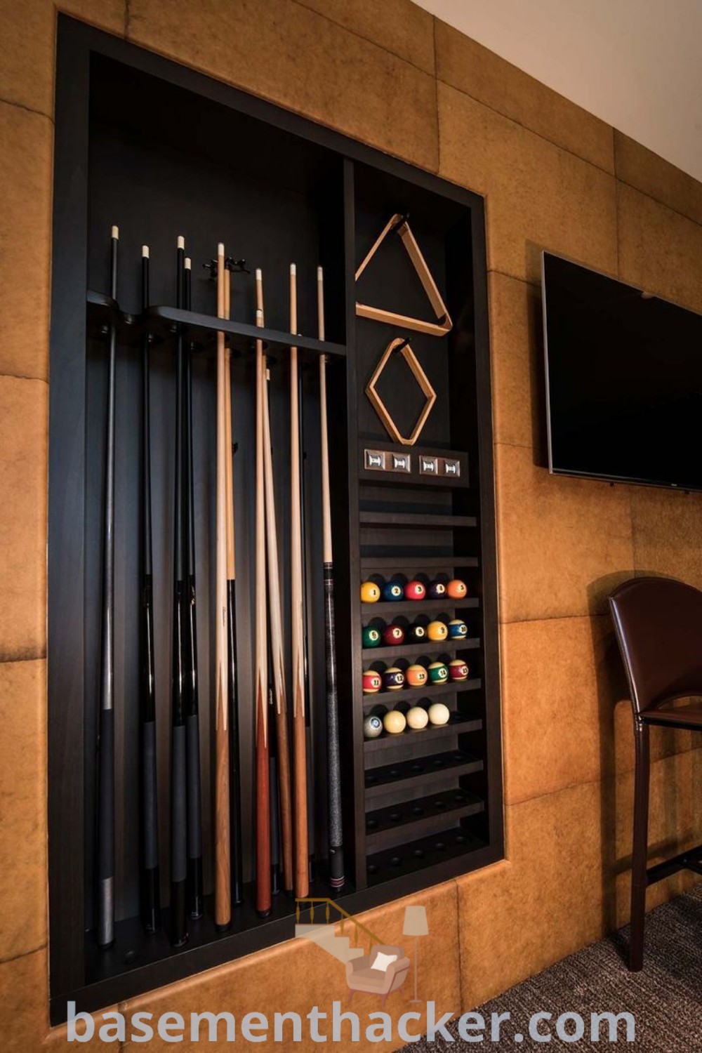 A wall-mounted billiards rack with pool cues arranged elegantly, designed for a stylish game room basement. This innovative decor piece enhances billiards room aesthetics and inspires ideas for a cozy and organized home. Find more design inspirations at basementhacker.com.
