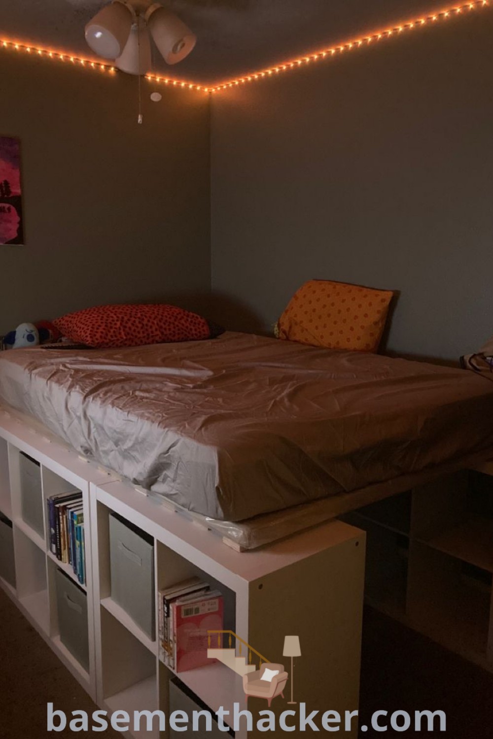 A stylish bed sitting on a white shelf with cube storage underneath, offering innovative ideas for a cozy and organized home. This Ikea shelving bed illustrates perfect functionality with a bookshelf loft design, ideal for maximizing space. For more inspiring designs, visit basementhacker.com.