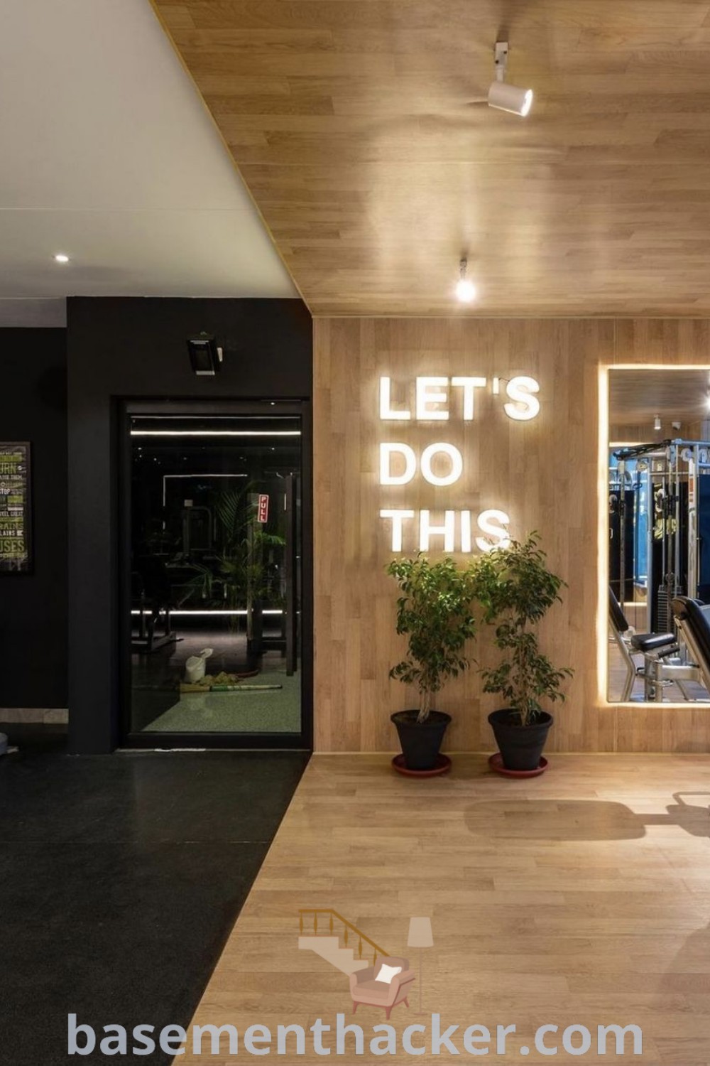 A modern home gym with exercise equipment and decorative plants, showcasing innovative ideas for designing a functional fitness space. This stylish gym setting offers inspiration for creating a private gym studio, incorporating elements like a ballet barre, and emphasizes the beauty of fitness decoration. Explore more ideas at basementhacker.com.